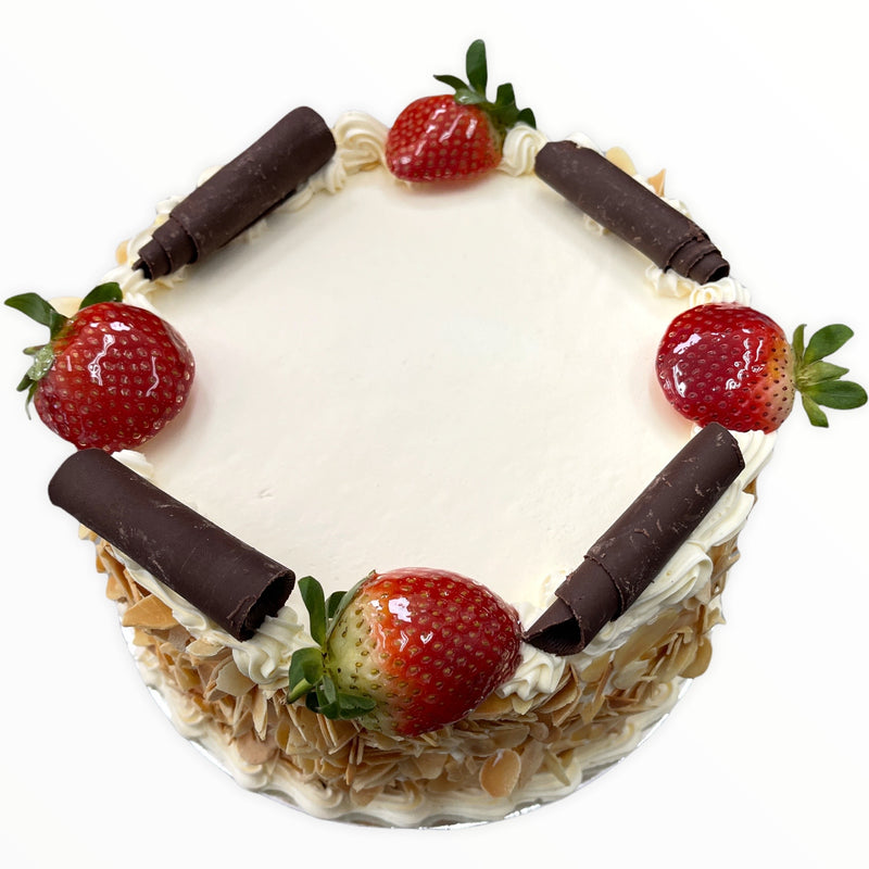 This traditional sponge is iced in real fresh cream, rolled in roasted flaked almonds, has fresh cream borders and is finished with freshly glazed strawberries and chocolate curls.